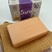 Bar of soap from the 'Little Soap Company' on a cloth with packaging in the background.